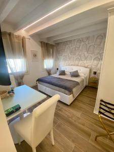 una camera con letto, tavolo e scrivania di Star Soave Rooms - Locazione Turistica a Soave