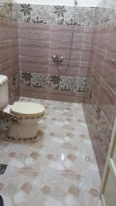 a bathroom with a toilet and a tile floor at Bob Marley Peace hostels luxor in Luxor