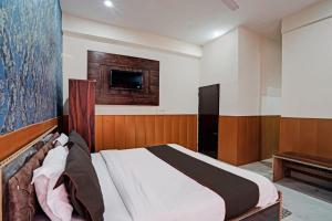 a bedroom with a bed and a tv on the wall at Blue Moon Inn in Greater Noida