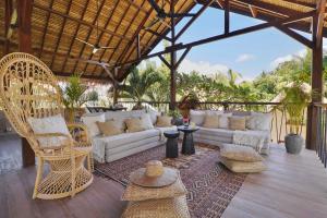 a living room with a white couch and chairs at Hani Hideaway in Gili Islands