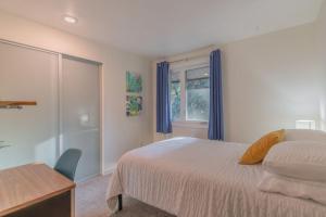 um quarto com uma cama, uma secretária e uma janela em The Upper Fairbanks Street Retreat 1 em Fairbanks