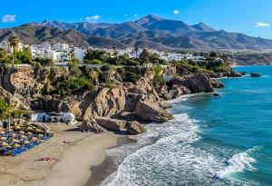 een uitzicht op een strand met rotsen en de oceaan bij El Capistrano Village Spacious home, large terrace in Nerja