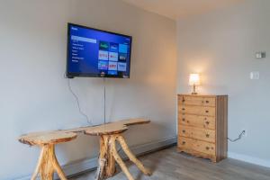 sala de estar con TV y mesa de madera en The Central Driftwood Inn 2, en North Pole