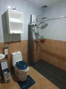 a bathroom with a toilet and a shower and a sink at Angeles Pool Villa in Angeles