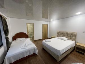 Monterrey的住宿－Centro agroecoturistico las heliconias，酒店客房,配有两张带白色床单的床