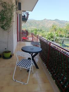 a table and a chair on a balcony at Il Melograno in Gaggi +1 photo