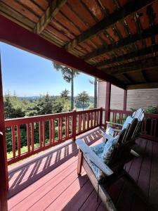 a porch with two chairs on a wooden deck at The Peregrine Suite - Comfort and Luxury in the Heart of Kodiak in Kodiak