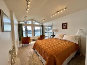 een slaapkamer met een groot bed en een raam bij The Captains View - Cliffside, Ocean Views in Kodiak