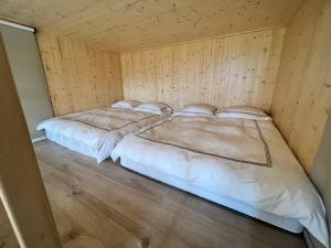 two beds in a room with wooden walls at Clouds Camping House in Nanzhuang