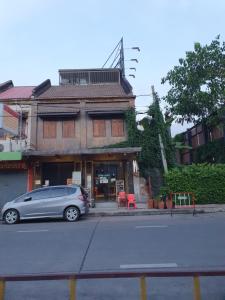 une voiture en argent garée devant un bâtiment dans l'établissement Baan Wualamphong บ้านวัวลำพอง, à Bangkok