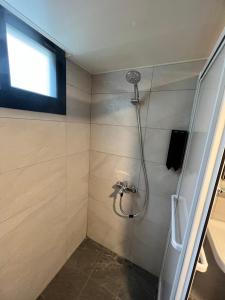 baño con ducha y puerta de cristal en Clouds Camping House, en Nanzhuang