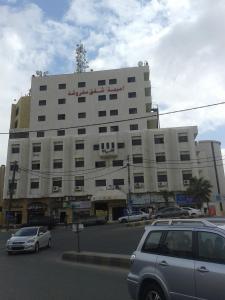 a large white building with cars parked in front of it at Omaima Hotel Apartments in Amman