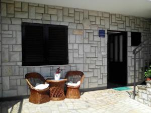 three chairs and a table in front of a stone wall at Apartment Poropat in Poreč