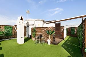 a patio with green grass and a fence at Suite Home Sagrada Familia in Barcelona