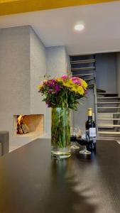 a vase of flowers on a table with a bottle of wine at Twins in Tbilisi City