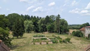 un jardin extérieur avec des plantes dans un champ dans l'établissement L'orcheran, à Vielverge