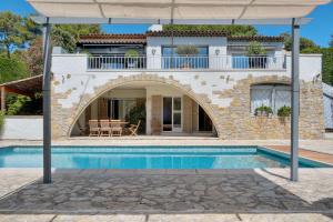 een villa met een zwembad en een parasol bij Private villa swimming pool hills Cannes in Vallauris
