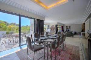 een eetkamer met een tafel en stoelen en een balkon bij Private villa swimming pool hills Cannes in Vallauris