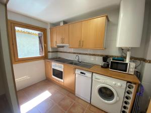 a kitchen with a washing machine and a sink at Casa Ega in El Pueyo de Jaca