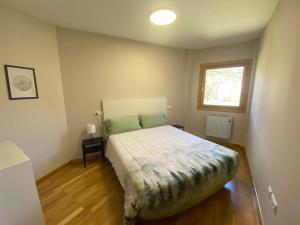 a bedroom with a bed and a window at Casa Ega in El Pueyo de Jaca