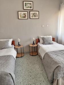 two beds in a room with two lamps on tables at Ibex Hill apartment in Lusaka