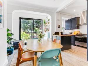 een keuken en eetkamer met een houten tafel en stoelen bij Pass the Keys Stunning 3BR House with Garden Oasis in Londen