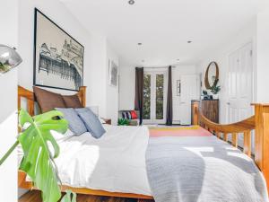 een slaapkamer met een groot bed en een plant bij Pass the Keys Stunning 3BR House with Garden Oasis in Londen