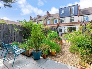 a garden with a chair and some plants at Pass the Keys Stunning 3BR House with Garden Oasis in London