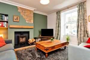 a living room with a fireplace and a tv at Finest Retreats - Upper Howick House in Alnwick