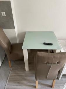 a glass table with a remote control on top of a chair at Ferienwohnung Monteurwohnung Kassel zentral ll in Kassel