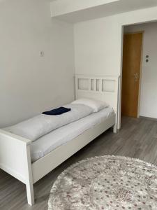 a bedroom with a white bed and a rug at Ferienwohnung Monteurwohnung Kassel zentral ll in Kassel