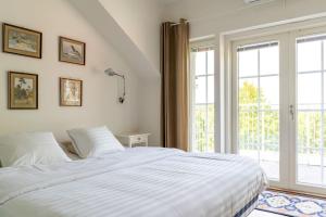 ein Schlafzimmer mit einem weißen Bett und einem großen Fenster in der Unterkunft Stunning Stone House w/ Sauna in Turku