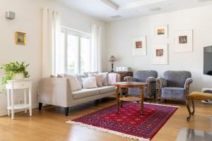 a living room with a couch and two chairs and a table at Stunning Stone House w/ Sauna in Turku