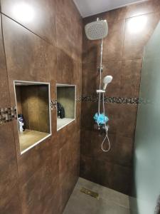 ein Bad mit einer Dusche mit braunen Fliesen in der Unterkunft Hotel Elen in Gjumri