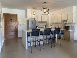 uma cozinha com uma mesa e cadeiras e um frigorífico em Marassi Marina Residences em El Alamein