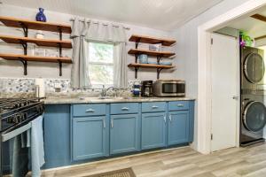 uma cozinha com armários azuis e um lavatório em Pet-Friendly Michigan Getaway with Porch and Kayaks! em Ontonagon