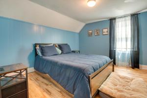 a blue bedroom with a bed and a window at Pet-Friendly Michigan Getaway with Porch and Kayaks! in Ontonagon