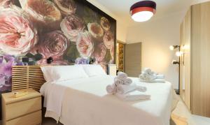 罗马PeoniaMaximaHouse -Piazza Bologna-的卧室配有一张大白色床,墙上挂着鲜花
