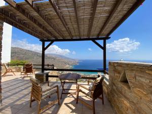 un patio con tavolo, sedie e vista sull'oceano di andros prive suites a Kipri