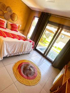 a room with two beds and a large window at Chalés Milagres Beach in São Miguel dos Milagres
