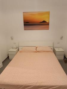 a bedroom with a bed with a painting on the wall at La Casetta di Elia in Lipari
