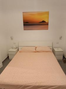 una camera da letto con un letto e un dipinto sul muro di La Casetta di Elia a Città di Lipari