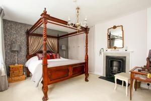 ein Schlafzimmer mit einem Himmelbett und einem Kamin in der Unterkunft Newgate House, Sandwich in Sandwich