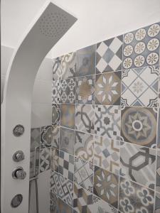 a bathroom with a tiled wall with a shower at La Casetta di Elia in Lipari