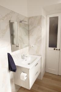 uma casa de banho branca com um lavatório e um espelho em Al n°35 - Una volta a Torino em Turim