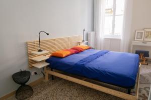 sypialnia z łóżkiem z niebieską pościelą i pomarańczowymi poduszkami w obiekcie Al n°35 - Una volta a Torino w Turynie