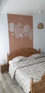 a bedroom with a bed with a comforter and clouds on the wall at Maison à deux pas de l'hôtel de ville in Calais
