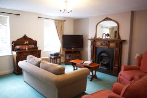 a living room with a couch and a fire place at Paddy Mac's Self Catering Holiday Bar in Drumshanbo