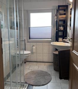a bathroom with a shower and a sink and a toilet at Ferienwohnung Mesdag in Lambertsberg