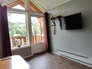 Habitación con ventana y TV en la pared. en Halland Camping, en Berkåk